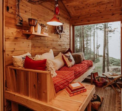 a living room with a couch in a log cabin at Treehouse-Small Eagles Perch over the water in Port Angeles