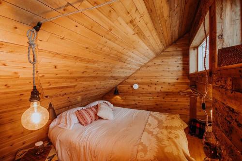 ein Schlafzimmer mit einem Bett in einem Holzzimmer in der Unterkunft Treehouse-Eagles Perch over the water in Port Angeles
