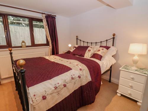 Schlafzimmer mit einem Bett und einem Fenster in der Unterkunft Tinkletod in Clevedon