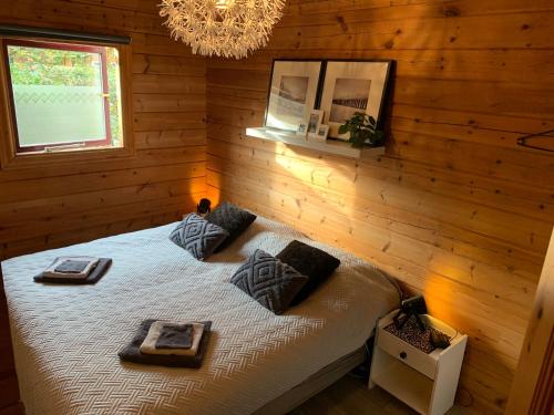 ein Schlafzimmer mit einem Bett in einer Holzwand in der Unterkunft Just Relax in Gramsbergen