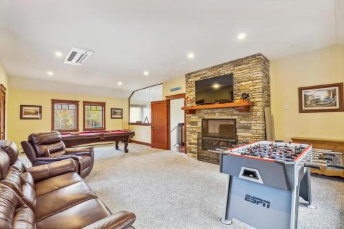 a living room with a pool table and a fireplace at Mountain Brook Lodge in Killington