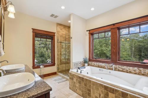 a bathroom with a tub and a sink and a shower at Mountain Brook Lodge in Killington