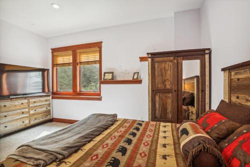 a bedroom with a bed and a flat screen tv at Mountain Brook Lodge in Killington