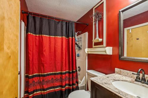 a red bathroom with a red shower curtain and a sink at Pinnacle E20 in Killington