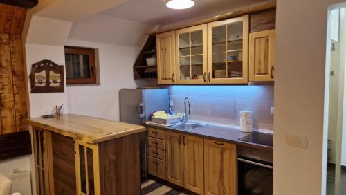 een keuken met houten kasten en een spoelbak bij Ski House in Kopaonik
