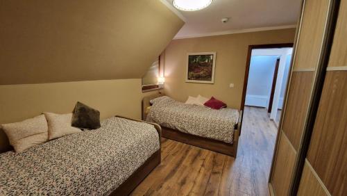 een kleine kamer met twee bedden en een spiegel bij Ski House in Kopaonik