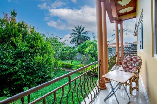 a balcony with a table and chairs and trees at Airport Side Hotel Entebbe in Entebbe