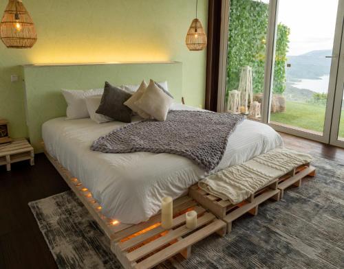 a bedroom with a large bed with lights on it at Sukha Resort in La Calera
