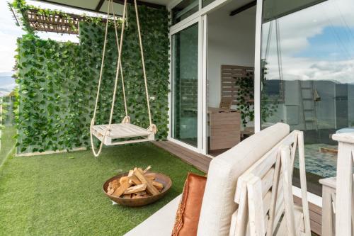 a swing on the porch of a house at Sukha Resort in La Calera