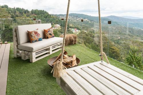 a porch swing with a chair on the grass at Sukha Resort in La Calera