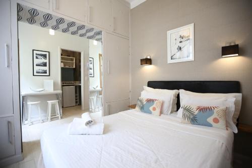 1 dormitorio con 1 cama blanca grande con almohadas en Unhotel - Charmoso Studio no Leblon, entre a Praia e Rua Dias Ferreira, en Río de Janeiro