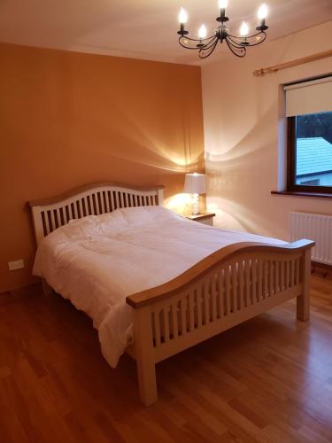 1 dormitorio con 1 cama blanca grande con lámpara de araña en Springmount Vacation, 