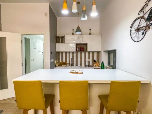 a kitchen with a white counter and yellow chairs at Apartman ''Silver fox'' Bjelašnica in Bjelašnica