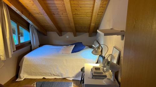 a bedroom with a bed and a desk with a phone at Villa Fleurettes STUDIO in Le Châble