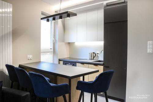 a kitchen with a table and chairs and a refrigerator at D Apartments Centrum Prowiantowa in Białystok