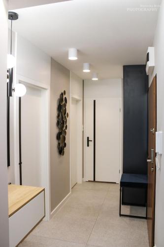 a hallway with white walls and a door with a blue chair at D Apartments Centrum Prowiantowa in Białystok