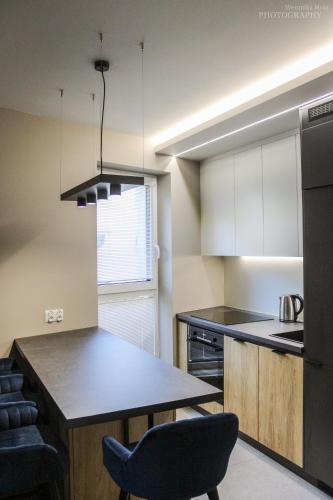 a kitchen with a table and a black refrigerator at D Apartments Centrum Prowiantowa in Białystok