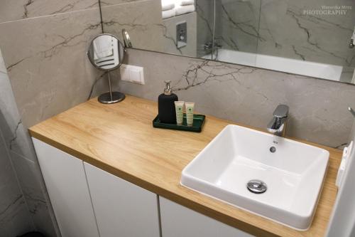 a bathroom counter with a sink and a mirror at D Apartments Centrum Prowiantowa in Białystok