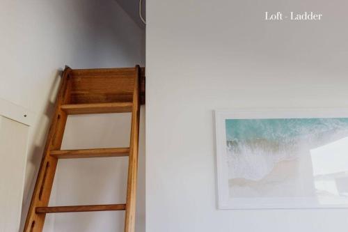 a wooden ladder leaning against a wall next to a painting at Miramar Beach House in Seymour