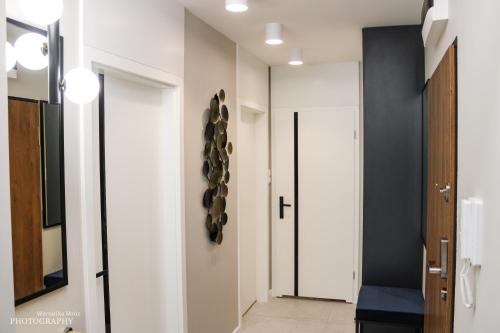 a hallway with white walls and a black and white door at D Apartments Centrum Prowiantowa in Białystok
