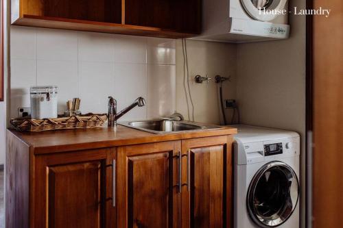 a kitchen with a sink and a washing machine at Miramar Beach House in Seymour