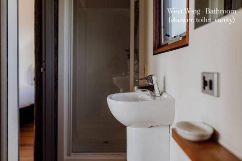 a bathroom with a white sink next to a door at Miramar Beach House in Seymour