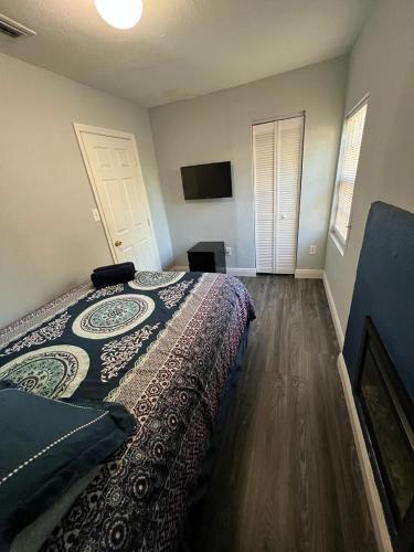 a bedroom with a bed and a flat screen tv at “La Casita” Beautiful home in the heart of Miami ! in Miami