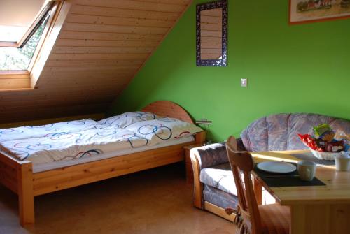 two beds in a room with green walls and a table at Gästezimmer Anita in Schwabach