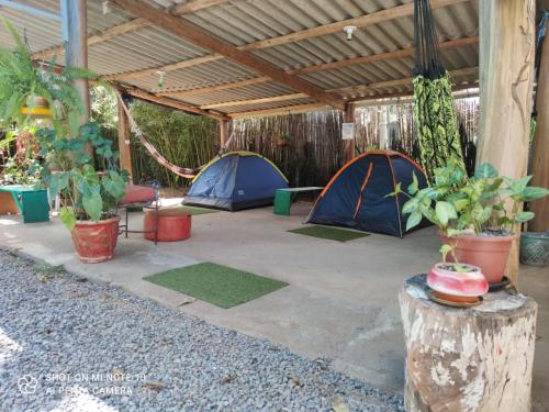 a patio with two tents and potted plants at Mandala Camping - Oferecemos um espaço para sua barraca in Alto Paraíso de Goiás