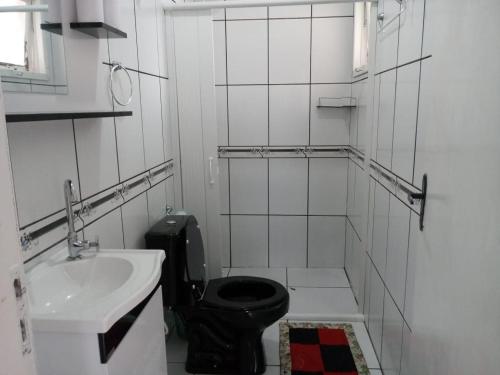 a bathroom with a black toilet and a sink at Casa 2 quartos - São Bernardo in São Francisco de Paula