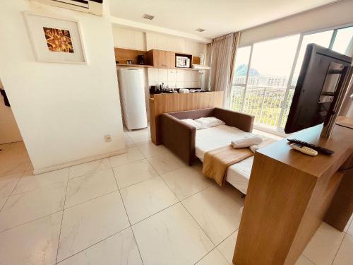 a living room with a bed and a television in it at Flat TOP e PERFEITO inteiro na Barra da Tijuca com cozinha, lavanderia, GARAGEM e wi fi in Rio de Janeiro