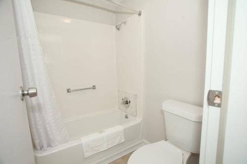 a white bathroom with a tub and a toilet at Travelodge by Wyndham Macon West in Macon