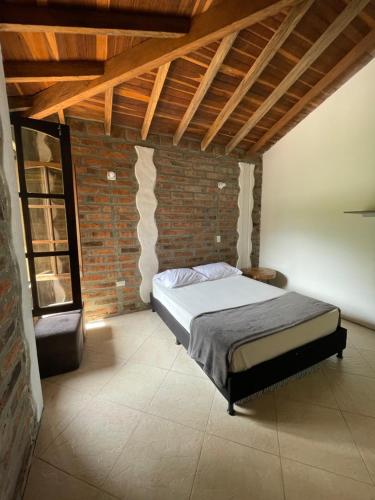 a bedroom with a bed in a brick wall at Finca Hotel Tierra Verde in Girardota