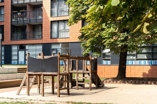 a wooden playground in front of a building at Scala City Center Premium Apartments with Parking by Lion Apartments in Gdańsk