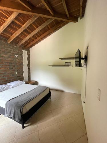 a bedroom with a bed and a brick wall at Finca Hotel Tierra Verde in Girardota