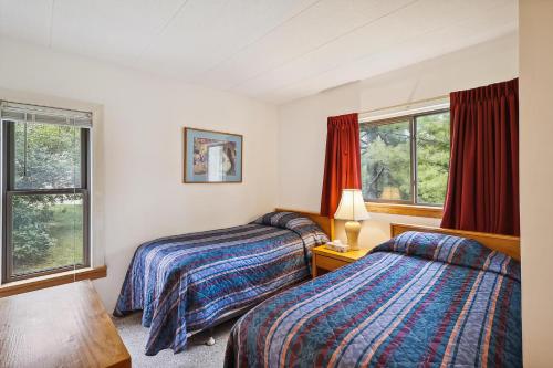 two beds in a room with two windows at Pinnacle E01 in Killington