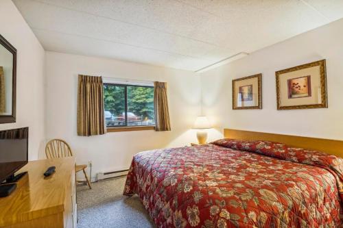 a hotel room with a bed and a desk and a window at Pinnacle A11 in Killington