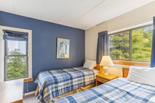 two beds in a room with two windows at Pinnacle E10 in Killington