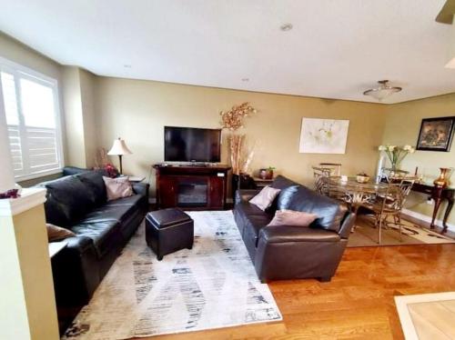 a living room with leather couches and a television at Top Floor of House in S Vaughan All to Yourself in Vaughan