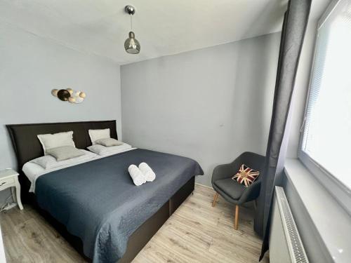 a small bedroom with a bed and a chair at The Apartment - Lenkas in Banská Bystrica