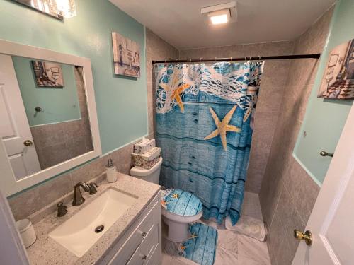 西棕櫚灘的住宿－4BR Downtown House Near Beach, Pet Friendly，浴室设有盥洗盆、卫生间和淋浴帘。