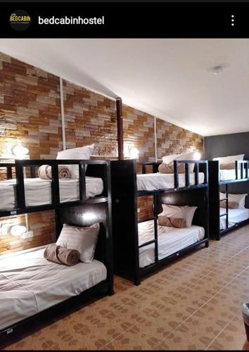 um quarto com três beliches num quarto em Bedcabin em Chiang Rai