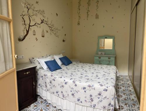 una camera da letto con letto, cuscini blu e specchio di Casa Lola a El Puerto de Santa María