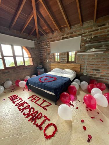 a bedroom with red and white balloons and a bed at Finca Hotel Tierra Verde in Belén