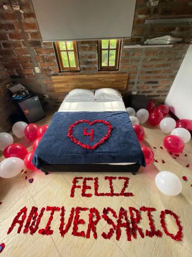 a bed with a heart on it with balloons on the floor at Finca Hotel Tierra Verde in Girardota