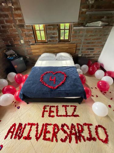 a bed with a heart on it with balloons on the floor at Finca Hotel Tierra Verde in Belén