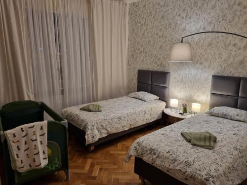 Pokój hotelowy z 2 łóżkami i krzesłem w obiekcie Apartament na Żeromskiego w mieście Gdynia