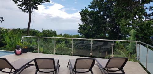 a patio with chairs and a table and a pool at La Vi la Bèl in Bouillante