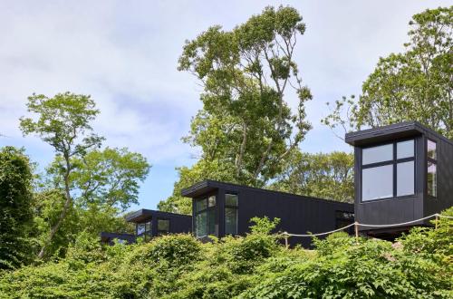 a black house on a hill with trees at AutoCamp Catskills in Saugerties