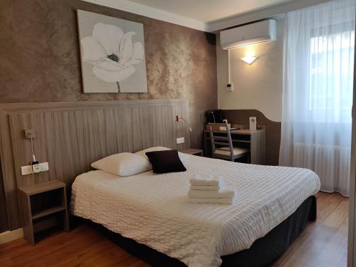 um pequeno quarto com uma cama e uma secretária em Hôtel Influences La Bresse em La Bresse
